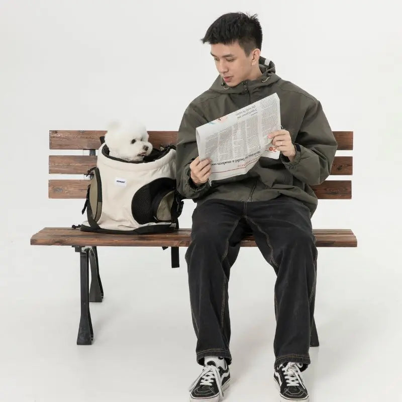 Man  relaxing in the park with pet carrier backpacks in beige